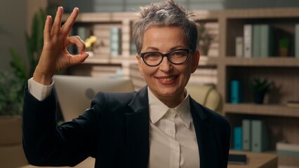 Portrait in office smiling happy successful Caucasian 60s woman 50s business female retired...