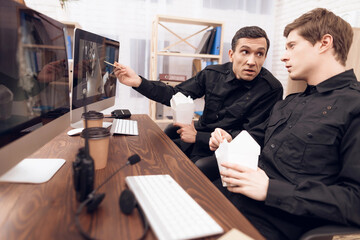Two guards have lunch in the workplace.