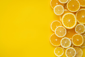 Refreshing assortment of sliced citrus fruits on vibrant yellow background