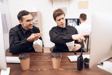 Two guards have lunch in the workplace.