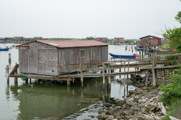 Old wooden fishing hut on stilts in coastal lagoon