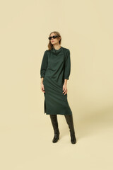 Fototapeta premium Serie of studio photos of young female model wearing green midi dress 