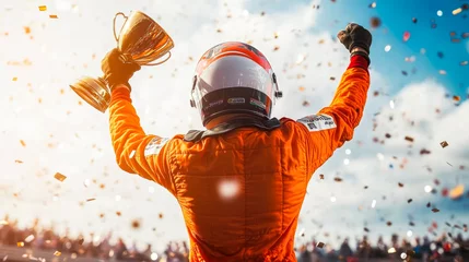  Formula 1 driver in orange uniform standing on the podium holding golden trophy cup, celebrating victory in Grand prix with fans. F1 winner raising hands up, confetti flying around. World champion © Dina Photo Stories