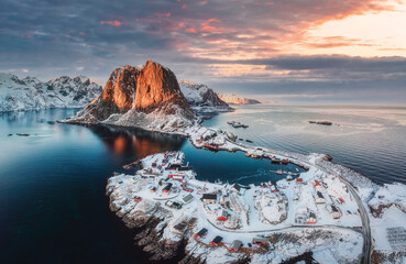 Landscape of aerial view of snowy mountain and fishing village on coastline in winter at Lofoten...