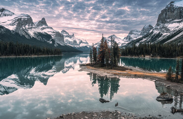 Man traveler jumping on lakeside in Spirit Island on Maligne Lake at Jasper National Park