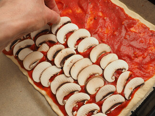 Man preparing a pizza with organic mushrooms, healthy delicious food