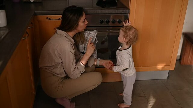 Mom teaches baby that it's dangerous to touch the oven