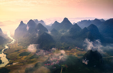 Beautiful sunrise over mountain range with foggy on rural village in Phong Nam Valley at Cao Bang, Vietnam
