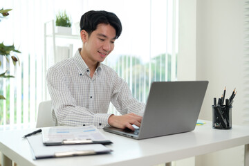 Young entrepreneur analyzing financial data on laptop and planning strategy at modern office.
