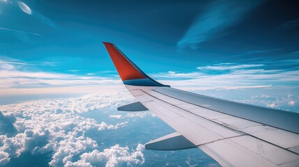 Fototapeta premium A stunning view of the airplane wing against the vibrant blue sky, capturing the vastness of the world below.