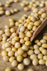 Fresh soybeans on a wooden shovel spoon with wooden background. Raw soybeans. Food ingredients