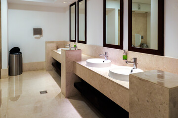 Round sinks and large mirrors in a public toilet.
