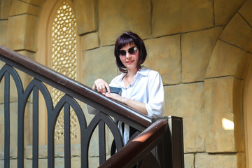 Woman inside arabic style room massive staircase.