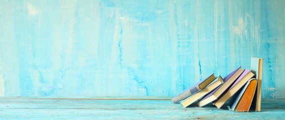Row of blue books on blue background. Reading,literature,education,book store,book fair,,home office concept, panoramic, large free copy space.