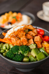 Salad bowl with broccoli, edamame, tofu, tempeh and fried egg. A delicious healthy meal with vegetables and nutritious protein
