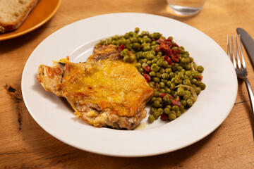 Delicious crispy chicken with peas as a side dish on a plate