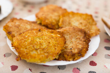 Potato pancakes with sour cream on white plate