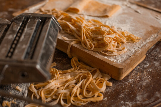 Generated imageA step-by-step visual story of making homemade Italian pasta, from kneading the dough to rolling and cutting it using a pasta machine. The rustic setup, fresh ingredients, and artisanal