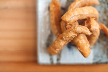 Crispy fried salmon belly served on a ceramic plate as a Japanese appetizer.
