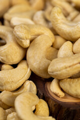 large cashew nuts are scattered on a larch board