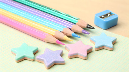 Colorful pencils and star shaped erasers create vibrant and playful stationery scene, perfect for inspiring creativity and fun