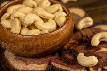 large cashew nuts are scattered on a larch board