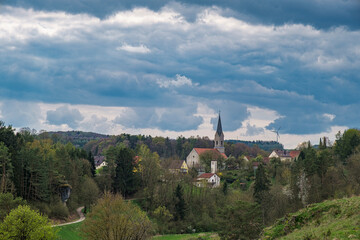 Fototapeta premium View of the village of Thuisbrunn in Franconian Switzerland on a cloudy spring day