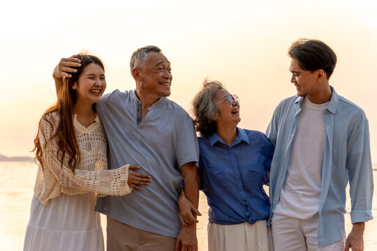 Happy family beach vacations.Group of multi generation family little girl with parents and grandparents relax and enjoy together on the beach.