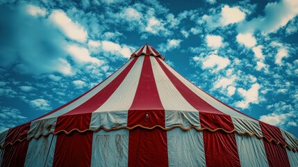 Red-white striped circus tent under a dramatic sky