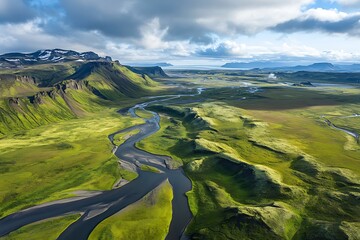 Fototapeta premium A serene river winding through a lush green valley under a clear blue sky.