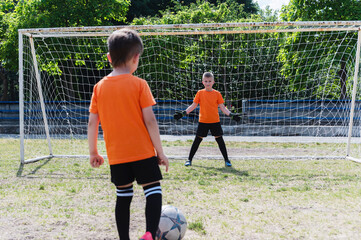 A boy football player prepares to take a penalty kick.
