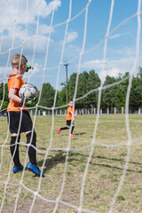 Goalkeeper boy pointing with hand before throwing the ball.