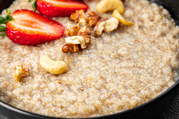 Oatmeal porridge with strawberries and nuts healthy breakfast appetizer dish fresh gourmet food background on the table rustic food top view copy space keto and paleo diet vegetarian and vegan food