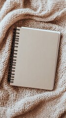 Minimalist Top View of Spiral Notebook on Cozy Beige Knitted Blanket