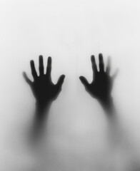 Creepy blurred hand shadows reaching out through translucent screen