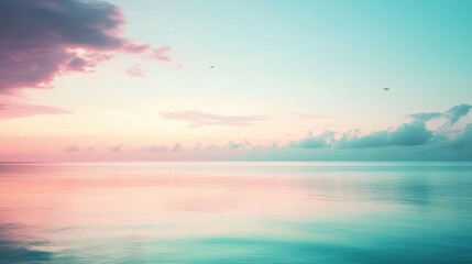 Fototapeta premium Soft pastel lavender and teal colors blend beautifully over a tranquil sea at sunrise