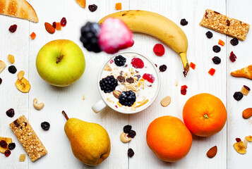 Healthy breakfast with yogurt, muesli, fresh and dried fruit falling in a cup