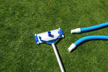tool to clean the pool at home on artificial grass. pool cleaner and tube