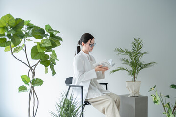 植物に囲まれた部屋の女性