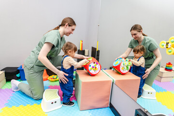 Rehabilitation session for a girl with her physical therapist in a playful manner with toys for...