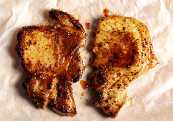 Two fried pork steaks on kraft paper top view