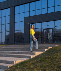 Fototapeta premium Portrait of a young beautiful woman on the background of an office building.