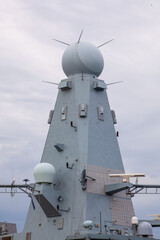 Close-up of a modern naval warship's radar tower with advanced surveillance and communication...