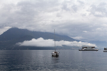 Fototapeta premium A dramatic and atmospheric photograph of a ship slowly navigating through the thick fog on Lake Como. 