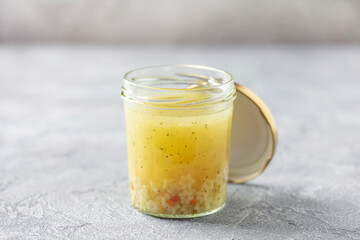 Chicken soup with starlet pasta in a glass jar on the table. Healthy office snack