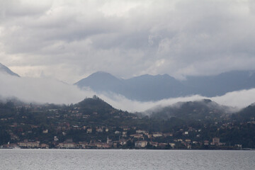A stunning shot of Lake Como enveloped in fog, with the charming lakeside city in the background.