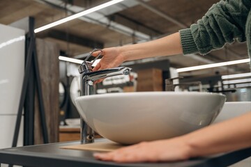 White sink. Close up view of woman that is in the hardware store