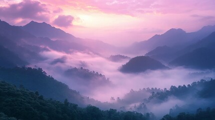 Fototapeta premium Misty mountain valley at sunrise, showcasing vibrant purple and pink hues in the sky and fog.