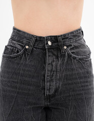 Woman showing her slim waist closeup. Girl in grey jeans demonstrates her slender waist and flat stomach abs after dieting on white background. High waist jeans