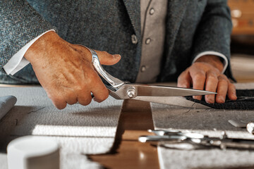 A charismatic tailor, deeply focused on his craft. His skilled hands carefully stitch fabric. A master of traditional handcraftsmanship, dedicated to every detail. Handcrafting in a sewing atelier